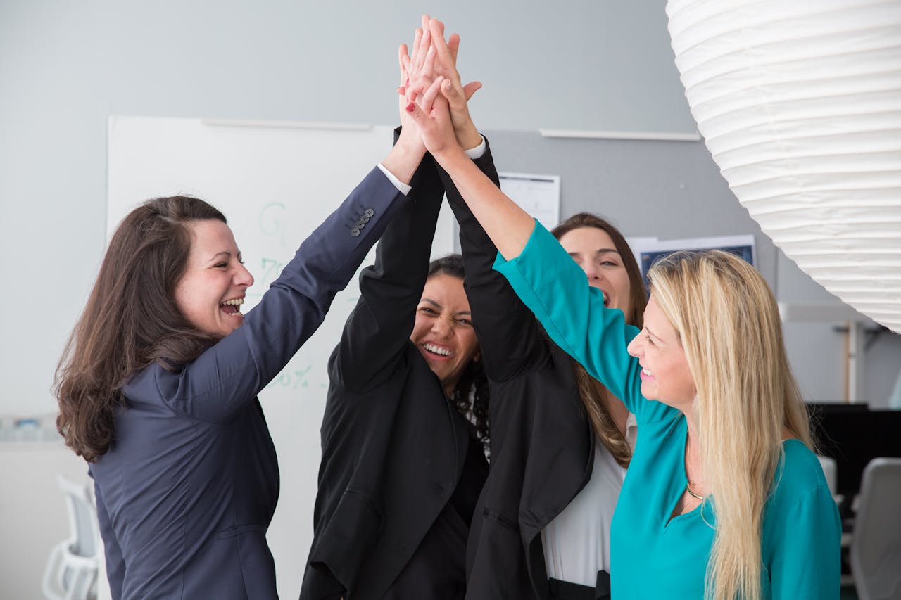 Crafting Captivating Headlines: Your awesome post title goes here Group of enthusiastic businesswomen achieving a success with a high five.